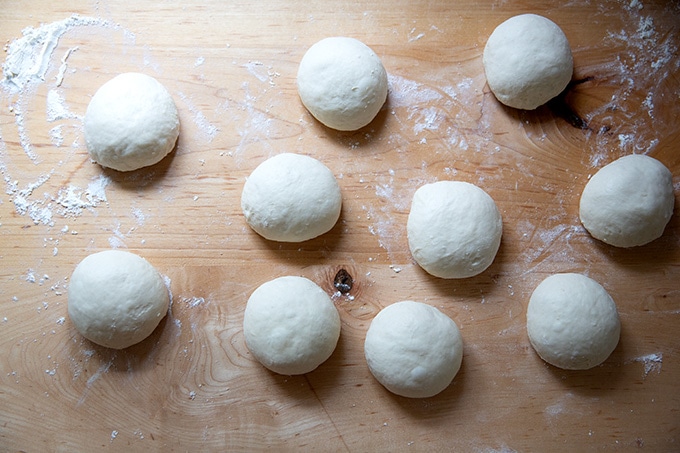 10 pretzel roll dough balls on a counter top.
