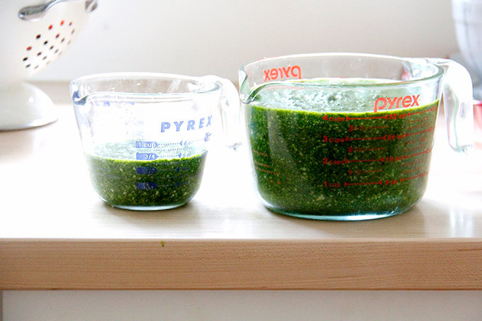 Two pyrex liquid measures filled with basil pesto.