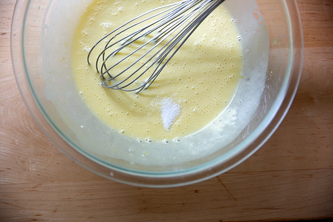A bowl of partially mixed lemon-blueberry quick bread batter with the salt just added.