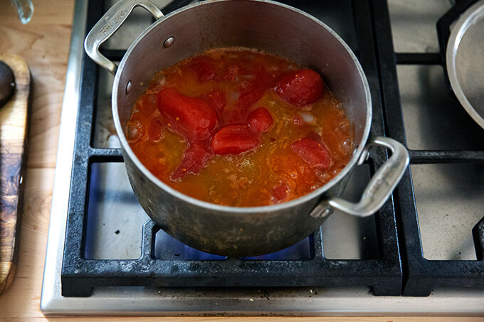 A pot of homemade tomato sauce simmering stovetop.