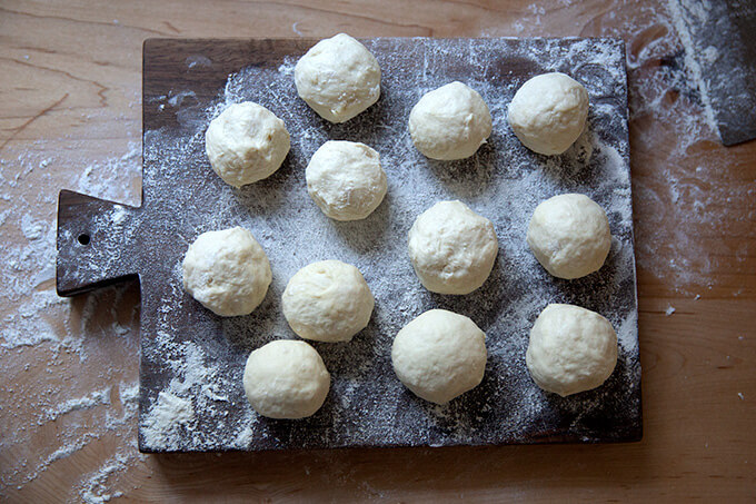 Flour tortilla dough balls on a floured work surface.