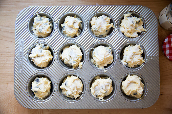 Blueberry muffin batter in a 12-cup muffin tin.