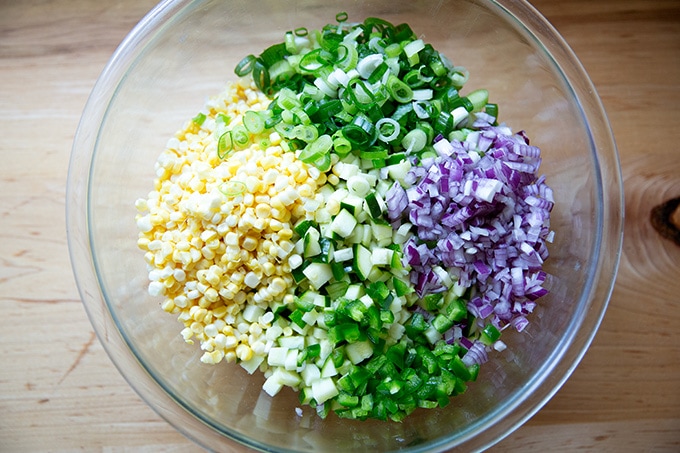A bean salad, ready to be tossed, in a large bowl.