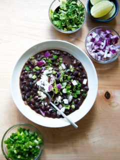 A bowl of Cal Peternell's black bean soup with garnishes.