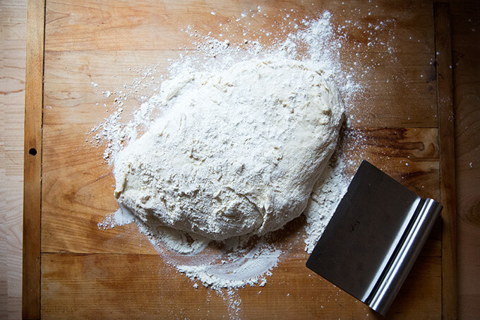 A floured work surface topped with homemade pizza dough. 