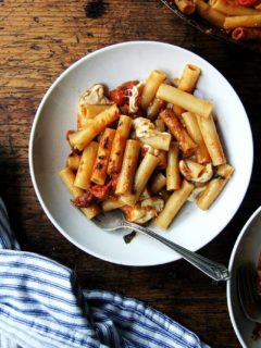 A bowl filled with the best one-pan baked ziti with a fork and napkin.