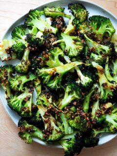 Spicy broiled broccoli with sesame-scallion oil on a plate.