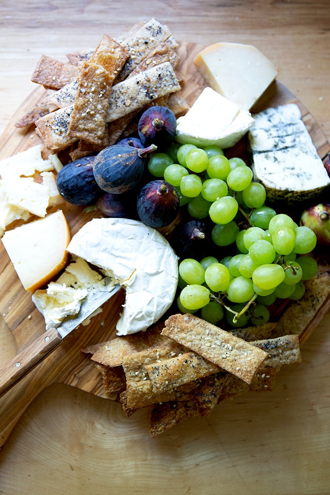 A cheese board with homemade sourdough crackers on it.