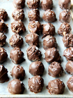 A sheet pan lined with chocolate covered peanut butter balls.