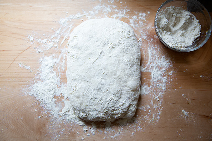 A shaped rectangle of sourdough ciabatta dough on a floured work surface.
