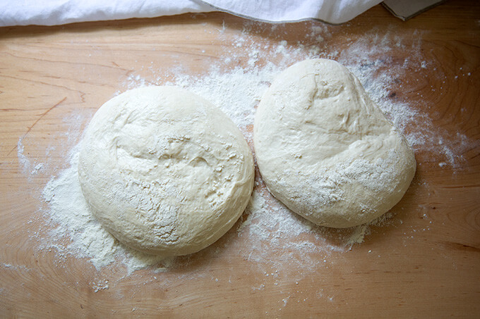 Ciabatta dough balls on a floured work surface.