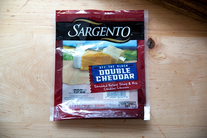 A bag of pregrated cheddar cheese.