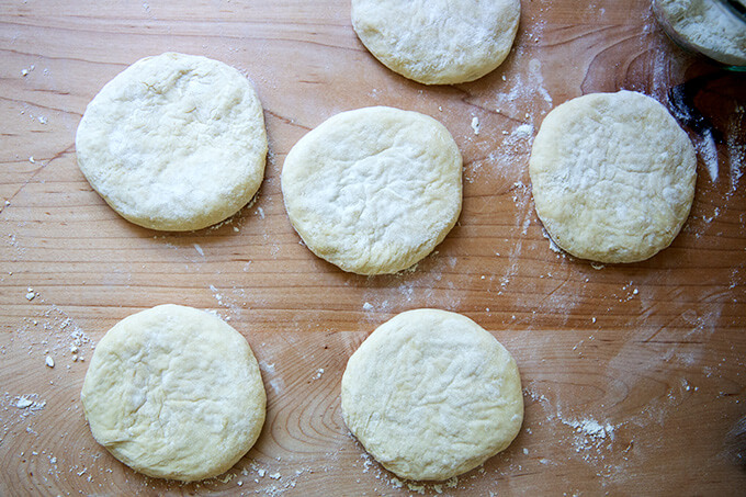 Six portions of pita bread dough, flattened out.