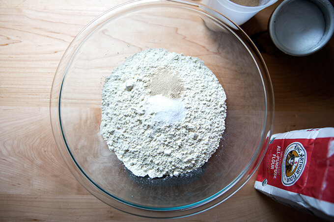 A bowl filled with flour, salt and yeast ready to make the simplest homemade pizza dough recipe ever.