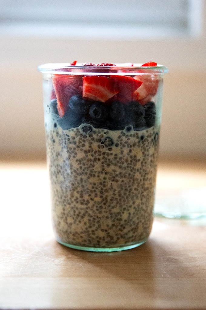 A Weck jar filled with overnight chia oats topped with blueberries and strawberries.