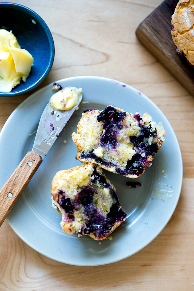 A halved blueberry muffin with melted butter.