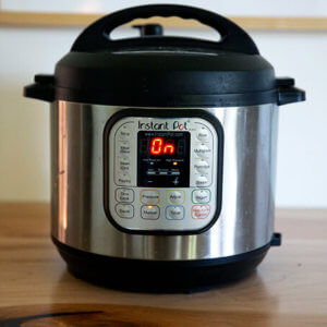 An Instant Pot on a counter turned on.