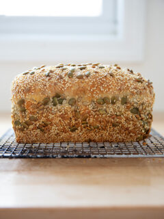 Just-baked three seed bread on a cooling rack.