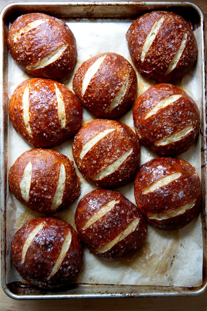 Just-baked pretzel rolls on a sheet pan.