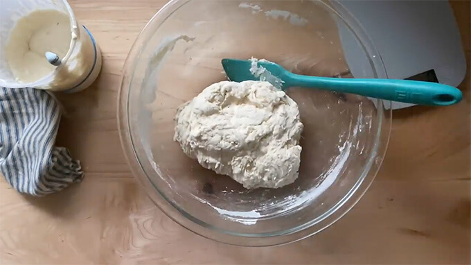 A bowl holding just-mixed sourdough bread dough.