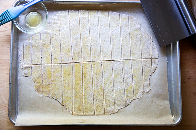 Unbaked sourdough crackers on a sheet pan.