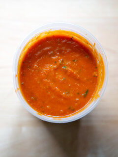 An overhead shot of homemade tomato sauce in a quart container.