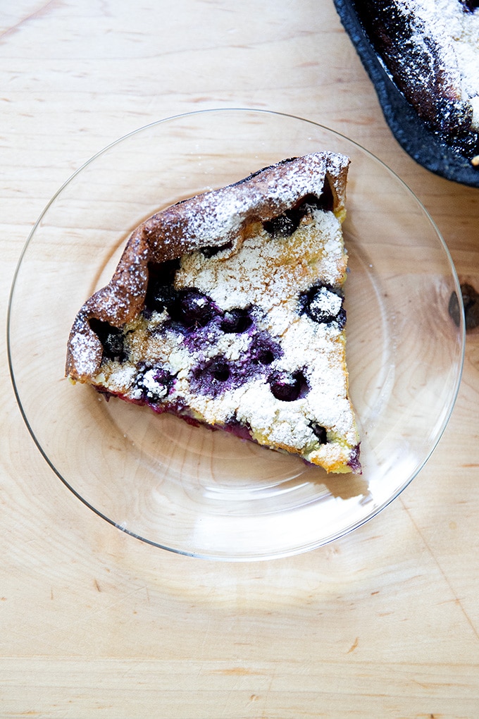 A slice of a blueberry Dutch baby on a plate.