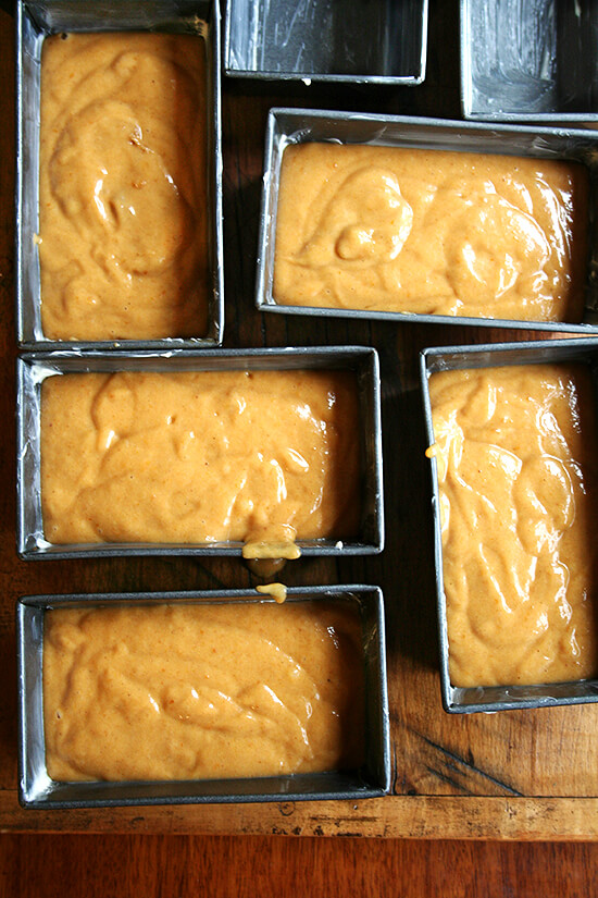 Five mini loaf pans filled with pumpkin bread batter.