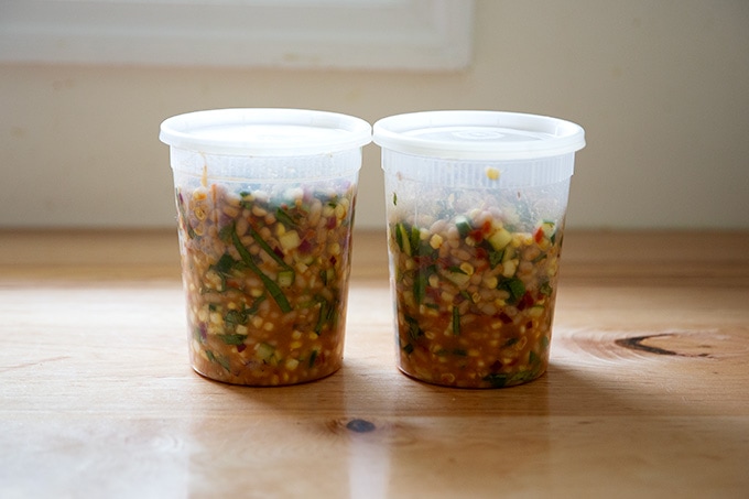 Two quart containers filled with a bean salad.