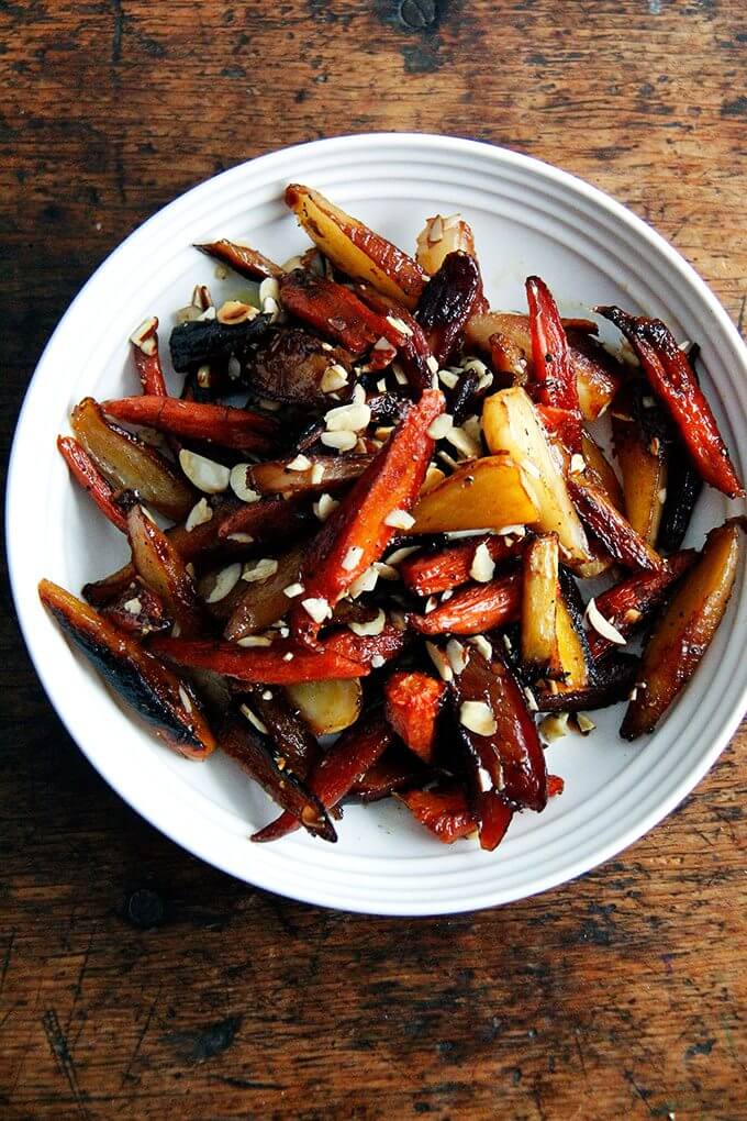 A bowl of roasted carrots with honey and almonds.