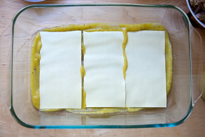 A layer of sauce and noodles in a 9x13-inch baking dish.