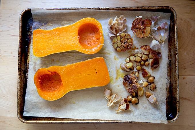A sheet pan of roasted butternut squash and roasted garlic.