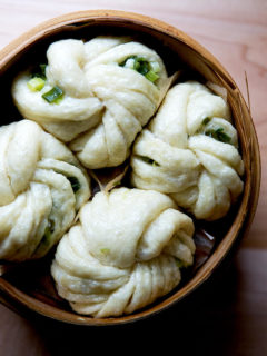 A steamer filled with Chinese steamed scallion buns.
