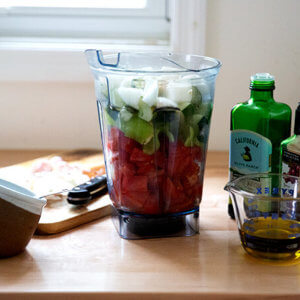 A vitamix filled with vegetables.